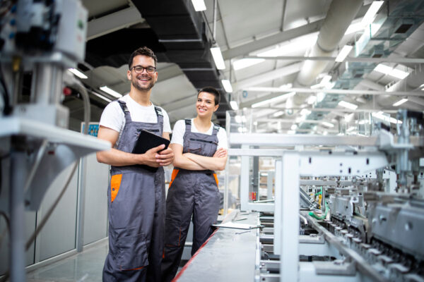 Portrait Of Production Line Workers Controlling Manufacturing Process 