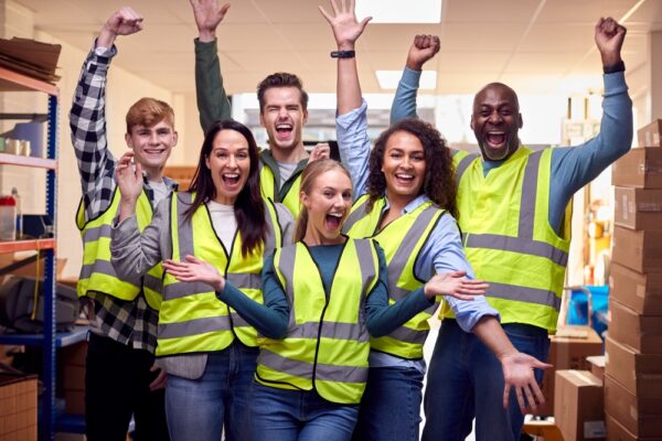 Portrait Of Cheering Multi-cultural Team Wearing Hi-vis Safety Clothing